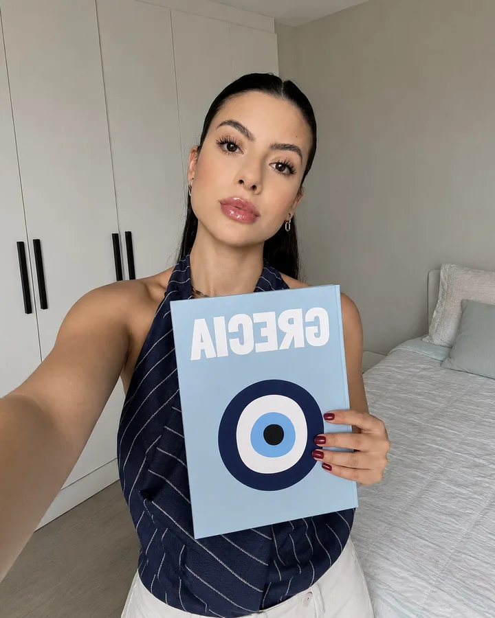 Clienta mostrando su photobook del viaje a Grecia